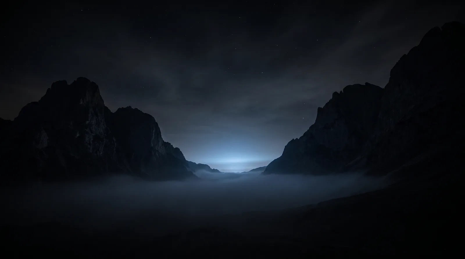 Duas montanhas frente a frente com uma luz azul emergindo do vale entre elas